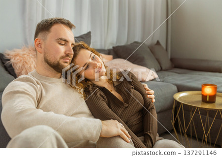 Happy couple cuddling on sofa at home romantic evening lifestyle Happy couple cuddling on sofa at home romantic evening lifestyle 137291146