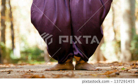 Indian woman barefoot in purple trousers dancing outdoors Indian woman barefoot in purple trousers dancing outdoors 137291455
