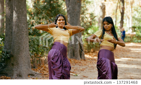 Indian women dancing traditional bollywood style outdoors 137291468