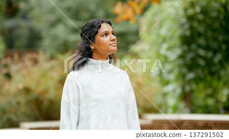 Indian woman looking up in park feeling peace Indian woman looking up in park feeling peace 137291502