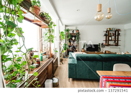 Bright living room with green sofa and houseplants 137291541