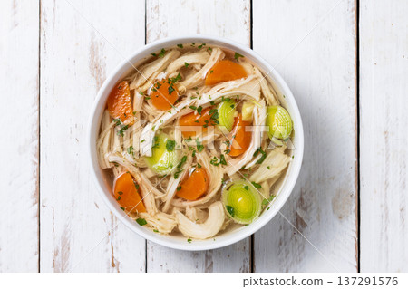 Homemade chicken soup in white bowl with carrots and celery 137291576