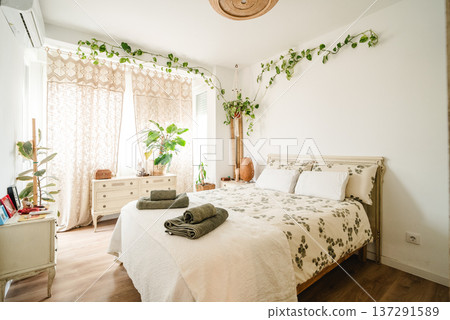 Boho bedroom decorating with plants creating cozy atmosphere Boho bedroom decorating with plants creating cozy atmosphere 137291589