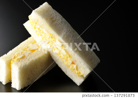 在黑色背景下拍攝的雞蛋三明治 137291873