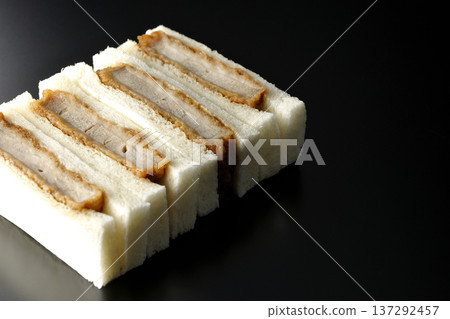 Photographing pork fillet cutlet sandwich against a black background 137292457