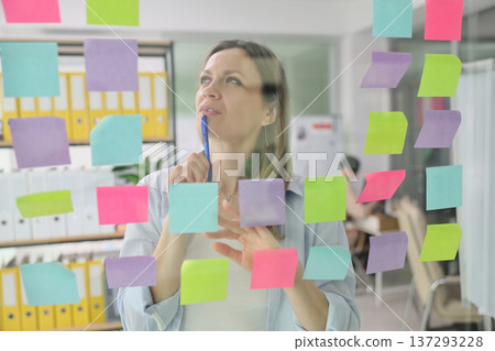 Creative brainstorming session with sticky notes in a modern office environment Creative brainstorming session with sticky notes in a modern office environment 137293228