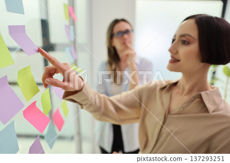 Creative brainstorming session in a bright modern office with colorful sticky notes 137293251