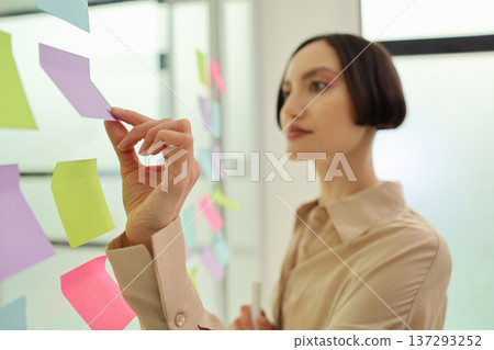 Creative brainstorming session sparks innovation with colorful sticky notes in a bright office space Creative brainstorming session sparks innovation with colorful sticky notes in a bright office space 137293252