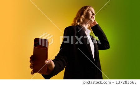 Business woman presenting smartphone toward camera on yellow green gradient background. 137293565