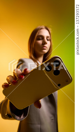 Woman holding smartphone with gradient background. Woman holding smartphone with gradient background. 137293572