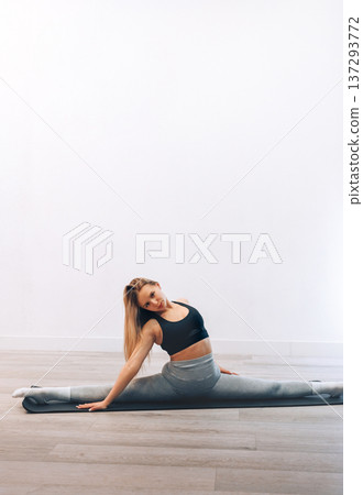 Woman Stretches Her Body While Practicing Yoga In Activewear At Home For Fitness. Girl Stretching, Enjoying Fitness Training Yoga And Healthy Lifestyle Woman Stretches Her Body While Practicing Yoga In Activewear At Home For Fitness. Girl Stretching, Enjoying Fitness Training Yoga And Healthy Lifestyle 137293772
