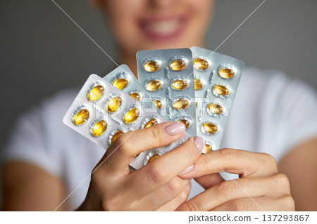 Medicine. Beautiful Smiling Woman Holding Blister Pack With Pills In Hand. Closeup Portrait Of Healthy Happy Girl With Tablets Medicine. Beautiful Smiling Woman Holding Blister Pack With Pills In Hand. Closeup Portrait Of Healthy Happy Girl With Tablets 137293867