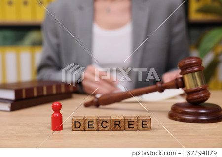 Legal professional reviews a decree with attention at the office as the gavel rests nearby on the polished desk 137294079