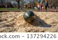 A rocket in the sand on a playground in a park during daylight. Conceptualizing the consequences of war, security issues and violations of the peace, and child safety. 137294226
