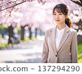 A woman in a suit and a row of cherry blossom trees 137294290