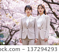 New female employees standing in a row under a cherry blossom tree 137294293