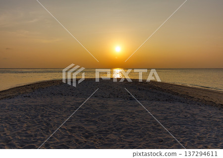 Sun dips low over calm ocean waters Sun dips low over calm ocean waters 137294611