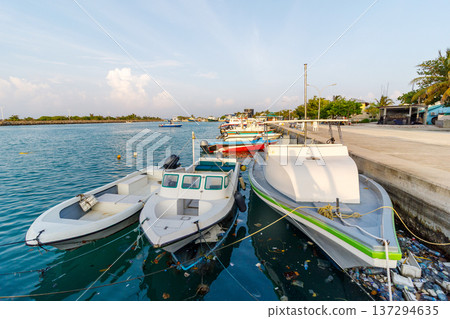 Calm waters reflect boats moored at a quiet dock Calm waters reflect boats moored at a quiet dock 137294635