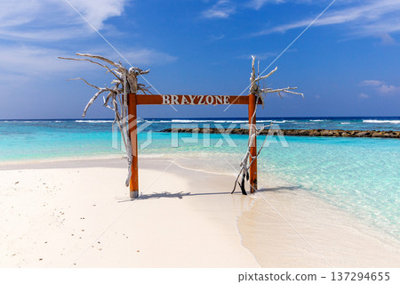 Whispering waves kiss soft white sand beneath a clear blue sky Whispering waves kiss soft white sand beneath a clear blue sky 137294655