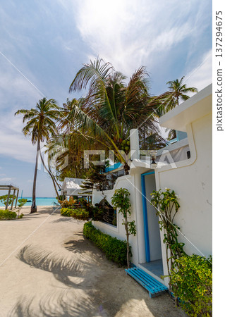 White cottage with blue door and steps 137294675