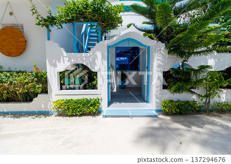 Bright blue door frames a cozy, inviting entrance Bright blue door frames a cozy, inviting entrance 137294676