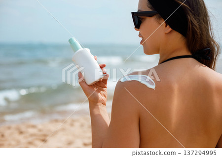 Back View Woman Applying Suncream Sunscreen Lotion on Shoulder 137294995