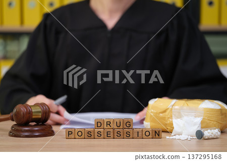 Judge presiding over drug possession case with evidence displayed on the courtroom table at a legal proceeding Judge presiding over drug possession case with evidence displayed on the courtroom table at a legal proceeding 137295168