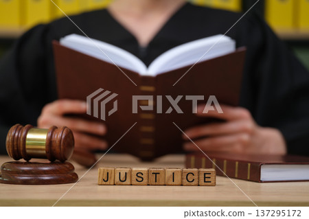 Gavel, book, and the quest for justice in a quiet courtroom setting 137295172