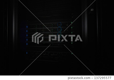 Server rack with illuminated network hardware and blinking LEDs in a dark data center Server rack with illuminated network hardware and blinking LEDs in a dark data center 137295577