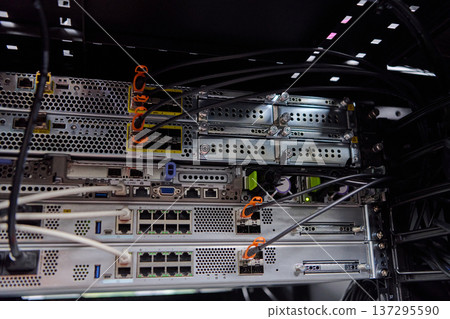 Rack-mounted servers and network cables in a data center server room showing IT infrastructure Rack-mounted servers and network cables in a data center server room showing IT infrastructure 137295590