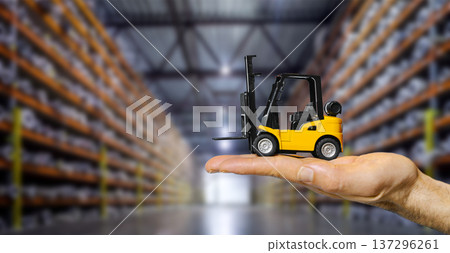 Forklift truck on hand in a large blurred warehouse. A creative concept showcasing logistics management Forklift truck on hand in a large blurred warehouse. A creative concept showcasing logistics management 137296261