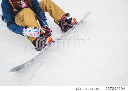 A woman wearing a snowboard A woman wearing a snowboard 137296304