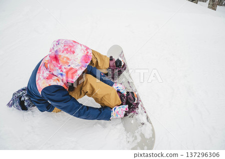 A woman wearing a snowboard 137296306