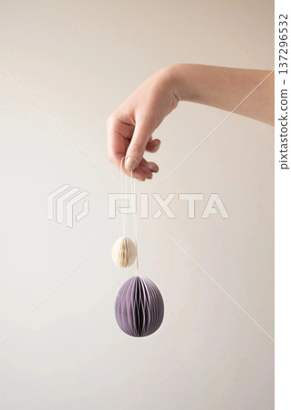 Woman Hand Holding Hanging Easter Egg Ornaments 137296532