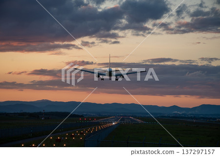 Jet plane landing at an airport at dusk Jet plane landing at an airport at dusk 137297157