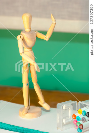 Wooden mannequin figure posing on a wooden table, Wooden mannequin figure posing on a wooden table, 137297399