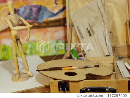 Wood mannequin with art palette and paintbrushes inspiring creativity Wood mannequin with art palette and paintbrushes inspiring creativity 137297405