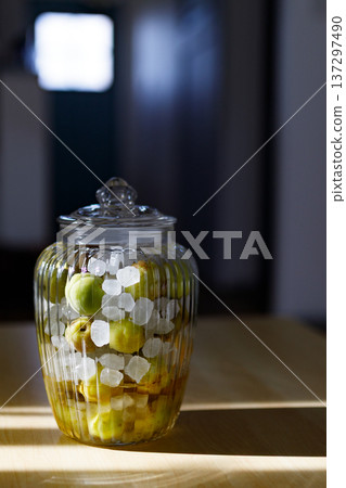 A storage jar of homemade plum syrup made with green plums and rock sugar A storage jar of homemade plum syrup made with green plums and rock sugar 137297490