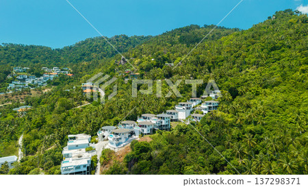 Aerial drone view of luxury hillside villas surrounded by tropical jungle on Koh Samui island in Thailand Aerial drone view of luxury hillside villas surrounded by tropical jungle on Koh Samui island in Thailand 137298371