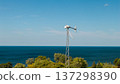 Broken small wind turbine near lake shoreline after strong storm or wind damage 137298390