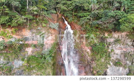 Drone aerial view of waterfall flowing over rocky cliff Drone aerial view of waterfall flowing over rocky cliff 137298599