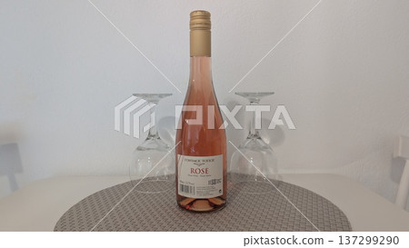 Bottle of Greek rose wine and two wine glasses on the table 137299290