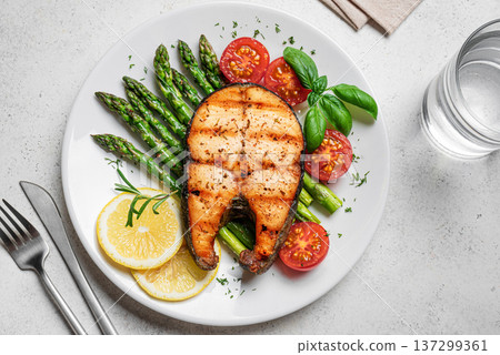 Grilled salmon steak with green asparagus, tomatoes and lemon slices Grilled salmon steak with green asparagus, tomatoes and lemon slices 137299361