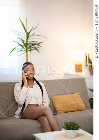 Young adult woman talking on phone enjoying conversation Young adult woman talking on phone enjoying conversation 137299414