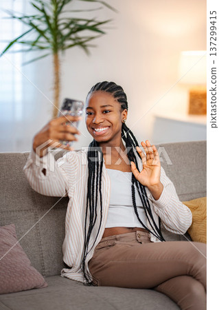 Young black woman waving during video call at home 137299415