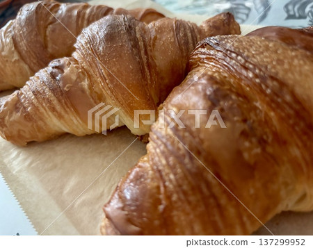 Freshly baked croissants lined up Freshly baked croissants lined up 137299952