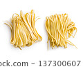 Fresh pasta ready for cooking, showing strands of fettuccine and bigoli set on a white background 137300607