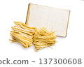 Fresh pasta ready for cooking and recipe book,, showing strands of fettuccine and bigoli set on a white background 137300608