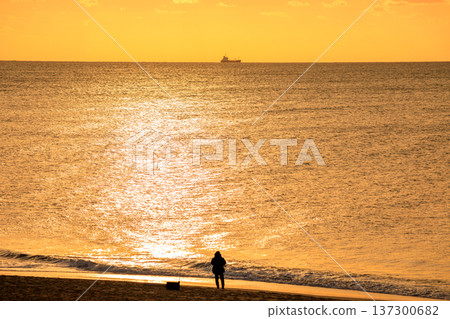 The sunlit sea and the silhouette of a fisherman 137300682