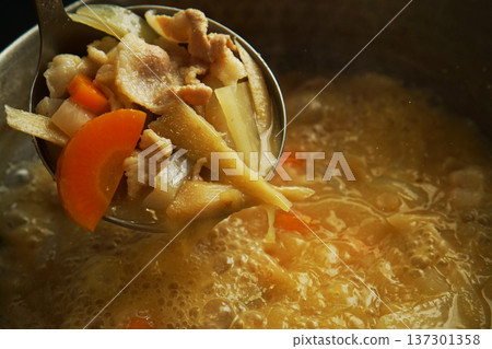 從鍋子裡舀出的豬肉湯食材 137301358